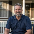 Portrait of Robert, 62, smiling on his Charleston front porch at sunset